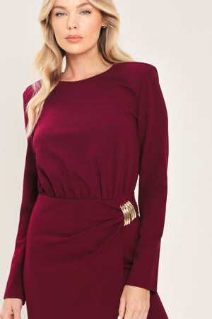 Woman wearing a long sleeve burgundy midi dress with a gold hardware holding slight gathered detailing around the hip | Flying Tomato