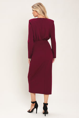 Woman wearing a long sleeve burgundy midi dress with a gold hardware holding slight gathered detailing around the hip | Flying Tomato