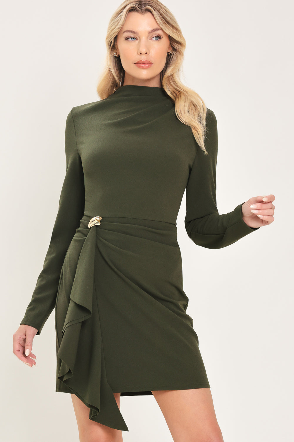 Woman wearing a long sleeve olive green mini dress with gathered fabric around the lower abdomen and fabric draping from a gold hardware a the corner of the waist | Flying Tomato