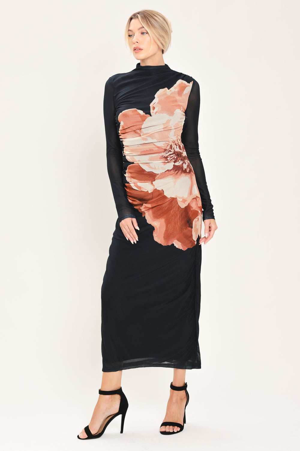 A woman modeling a black long-sleeve mock-neck mesh midi dress with a large abstract floral print in brown, beige, and white on the front | Flying Tomato