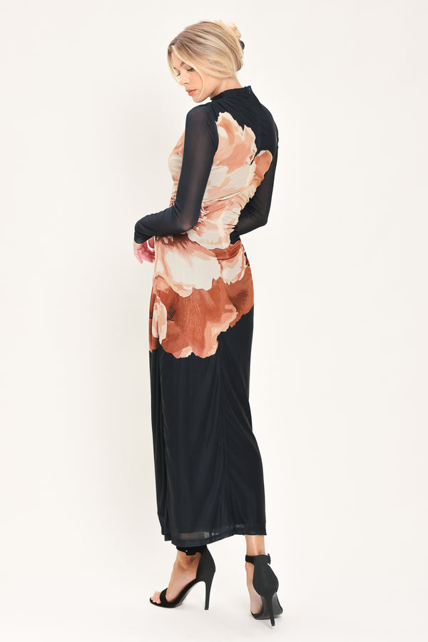 A woman modeling a black long-sleeve mock-neck mesh midi dress with a large abstract floral print in brown, beige, and white on the front | Flying Tomato