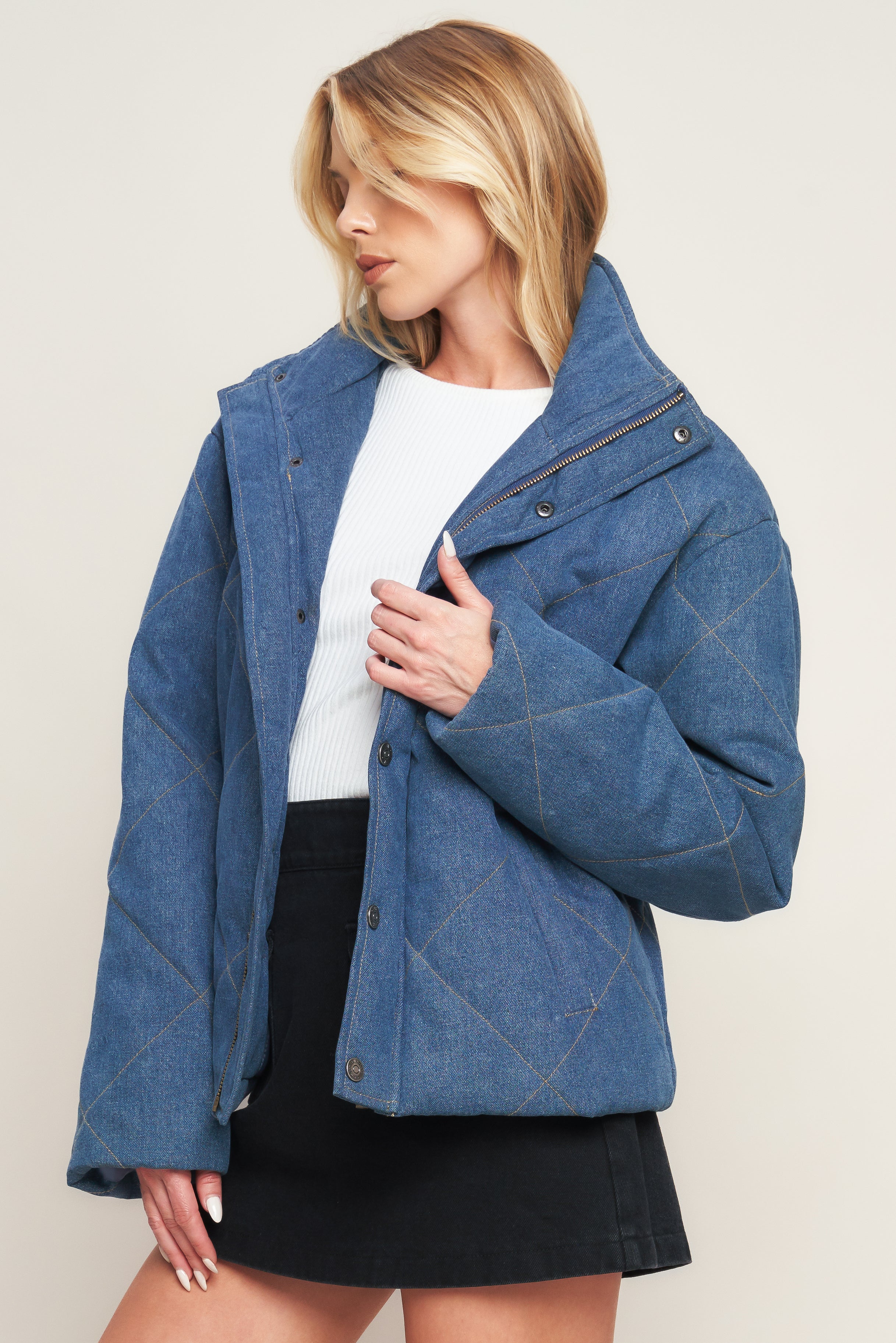 A denim quilted jacket featuring high neckline, long sleeve and front snap closure