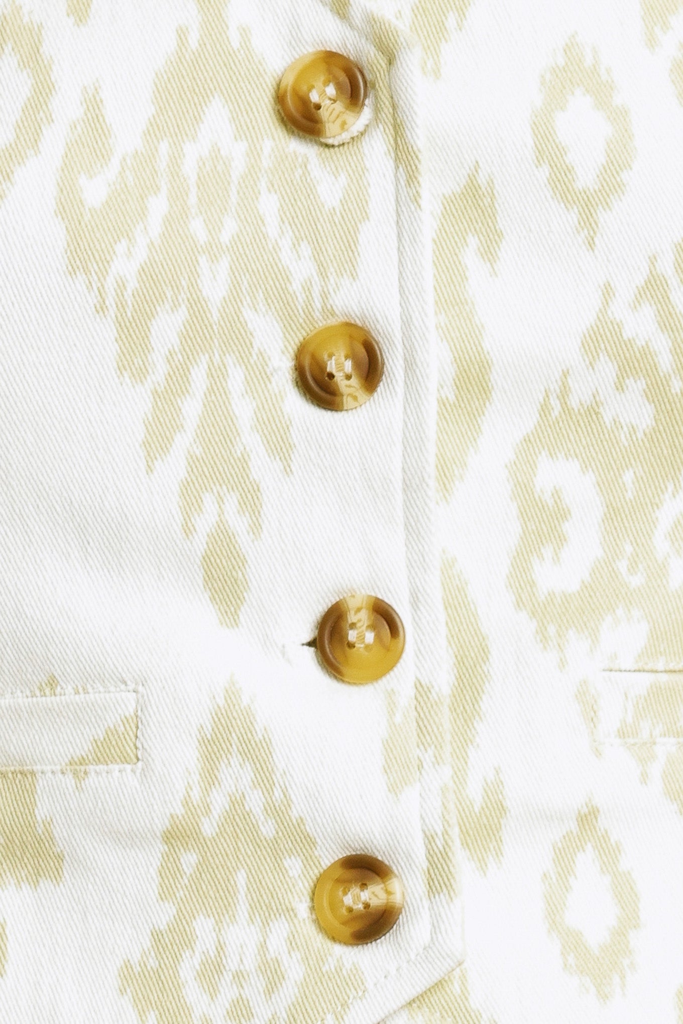 Close-up of a white shirt with gold buttons and abstract pattern | Flying Tomato