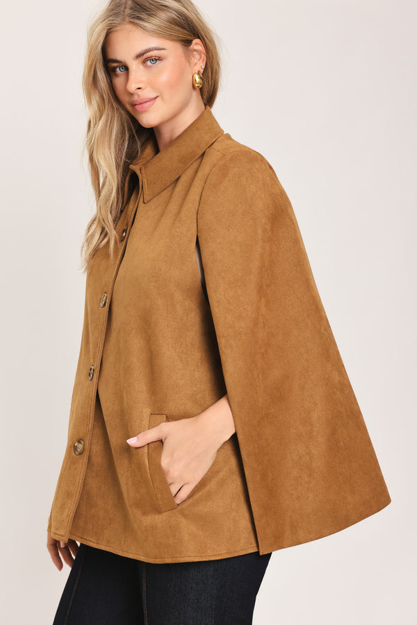 Woman wearing a camel suede capelet jacket with a collar, buttons, and matching  waist belt | Flying Tomato
