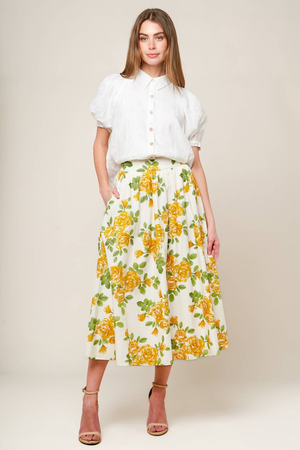 A cream woven full skirt featuring yellow floral print, side zipper closure and pockets.