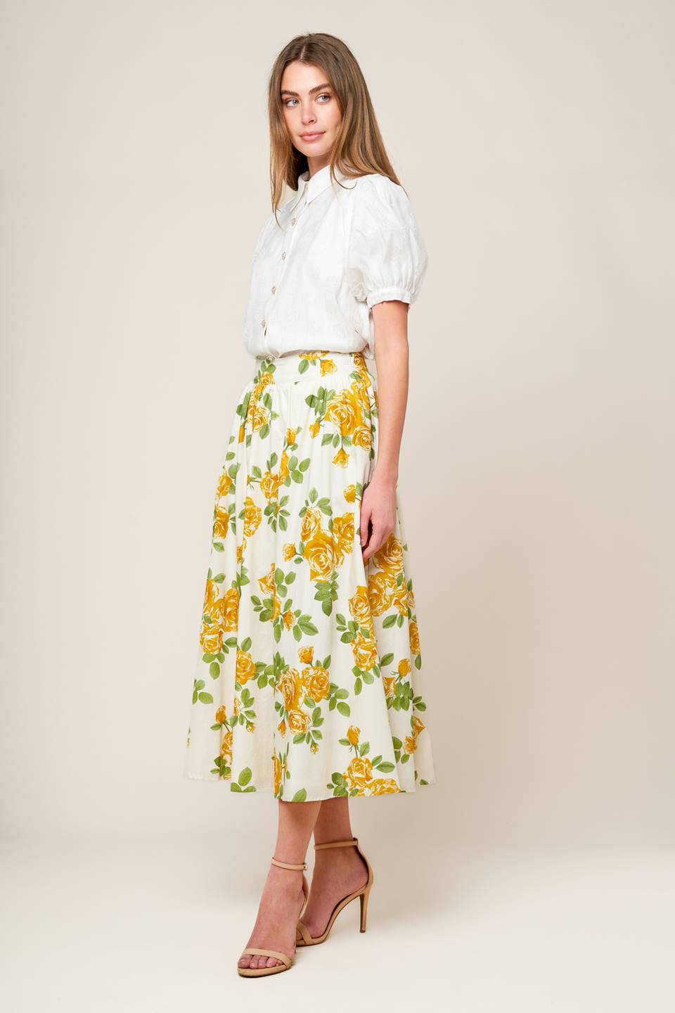 A cream woven full skirt featuring yellow floral print, side zipper closure and pockets.