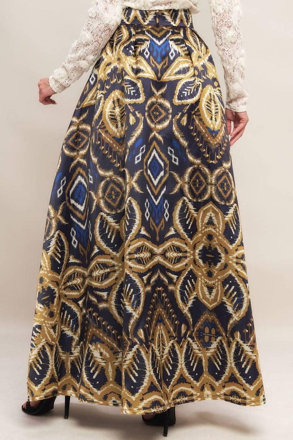 A printed woven maxi full skirt with side zipper closure and self belt.