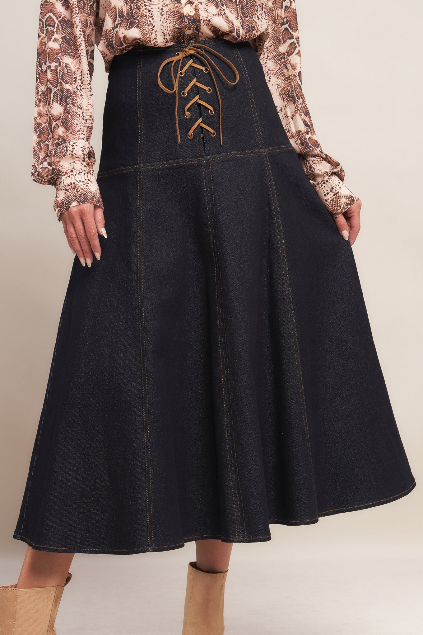 A denim midi skirt featuring front lace up detail and back zipper closure