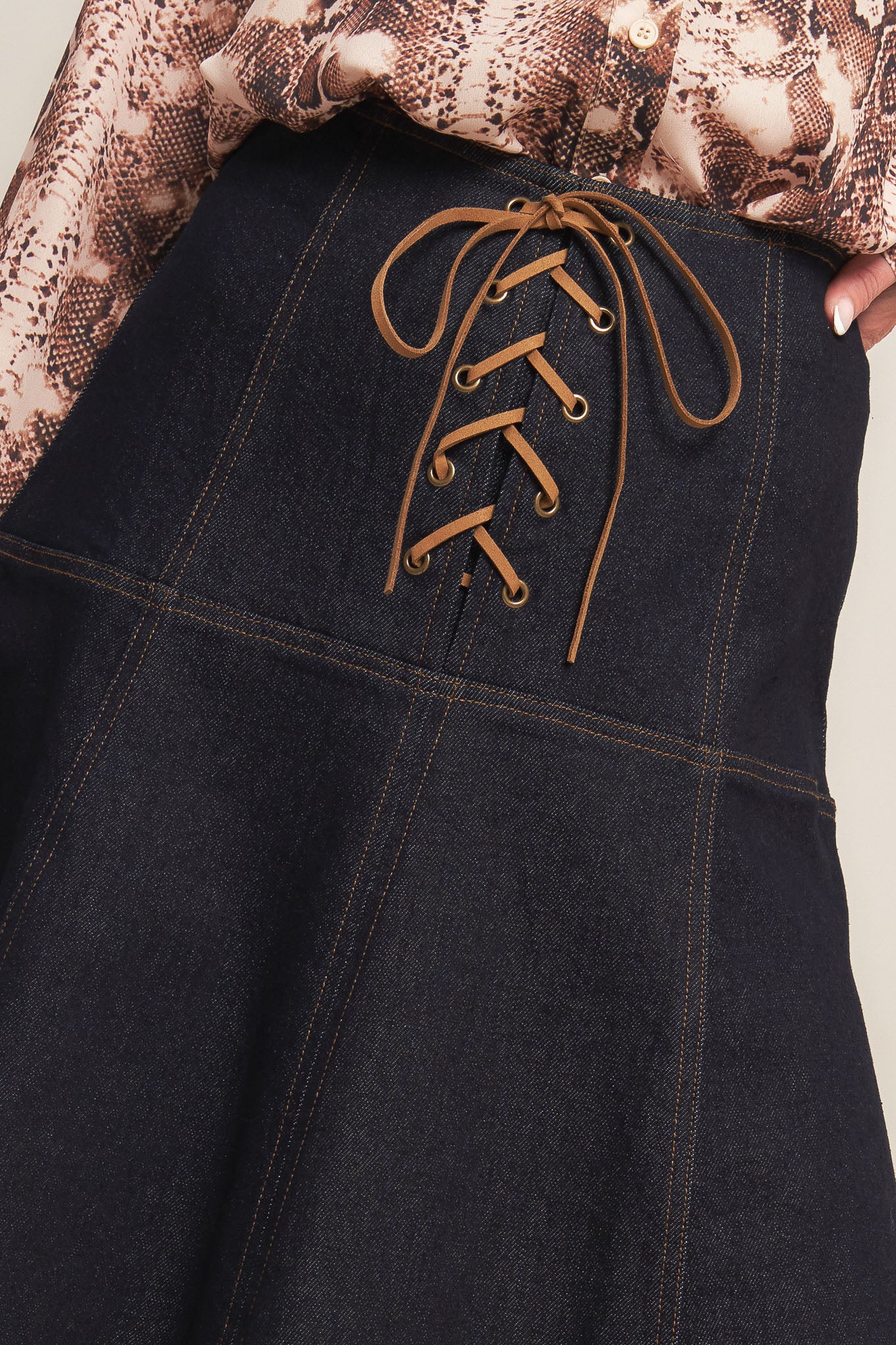 A denim midi skirt featuring front lace up detail and back zipper closure