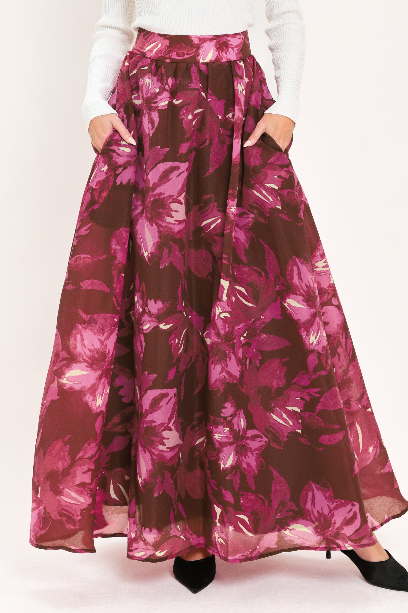 A model wearing a high-waisted, floor-length maxi A-line skirt with a dark burgundy base and a vibrant magenta floral pattern | Flying Tomato