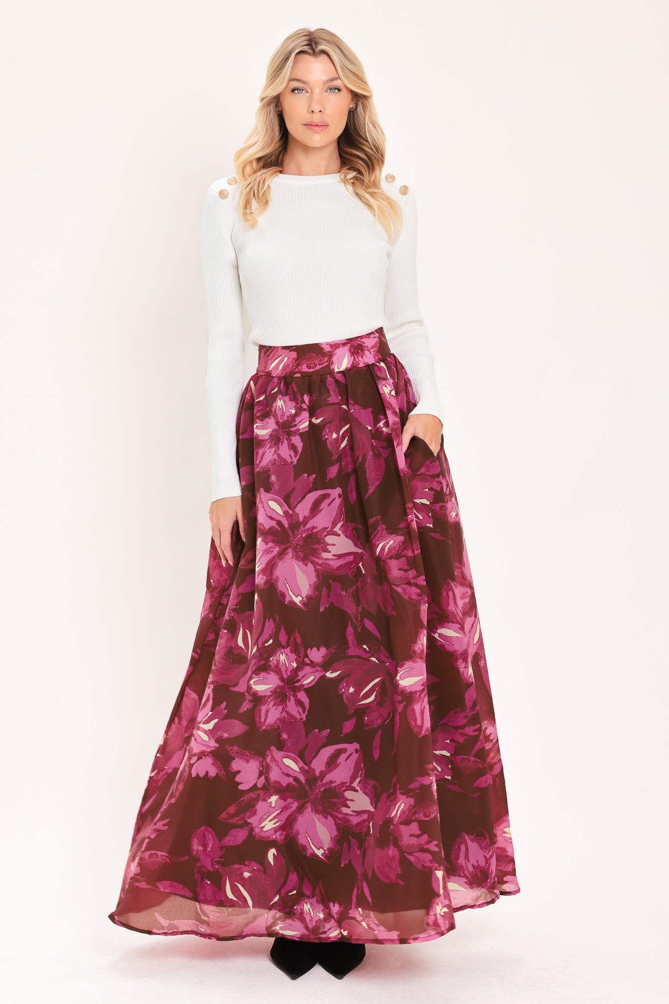 A model wearing a high-waisted, floor-length maxi A-line skirt with a dark burgundy base and a vibrant magenta floral pattern | Flying Tomato