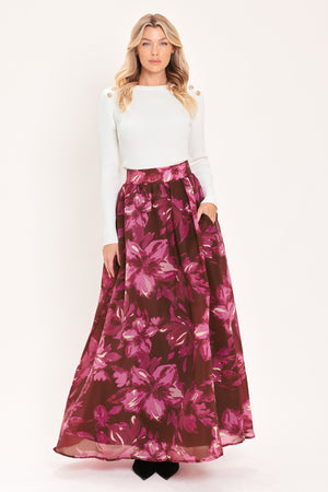 A model wearing a high-waisted, floor-length maxi A-line skirt with a dark burgundy base and a vibrant magenta floral pattern | Flying Tomato