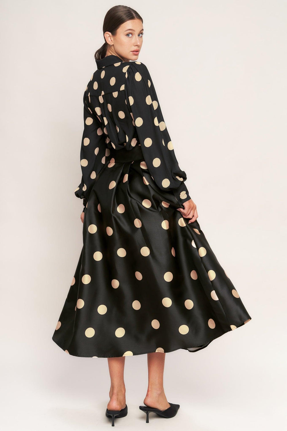 A polka-dotted printed woven full midi skirt featuring side zipper closure with tie.