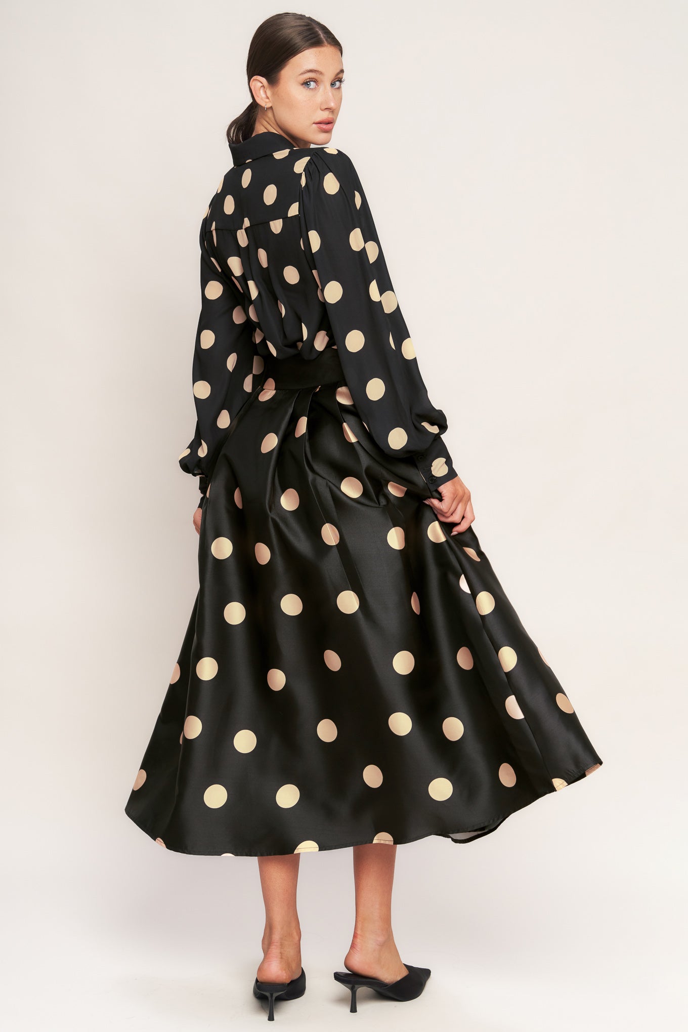 A polka-dotted printed woven full midi skirt featuring side zipper closure with tie.