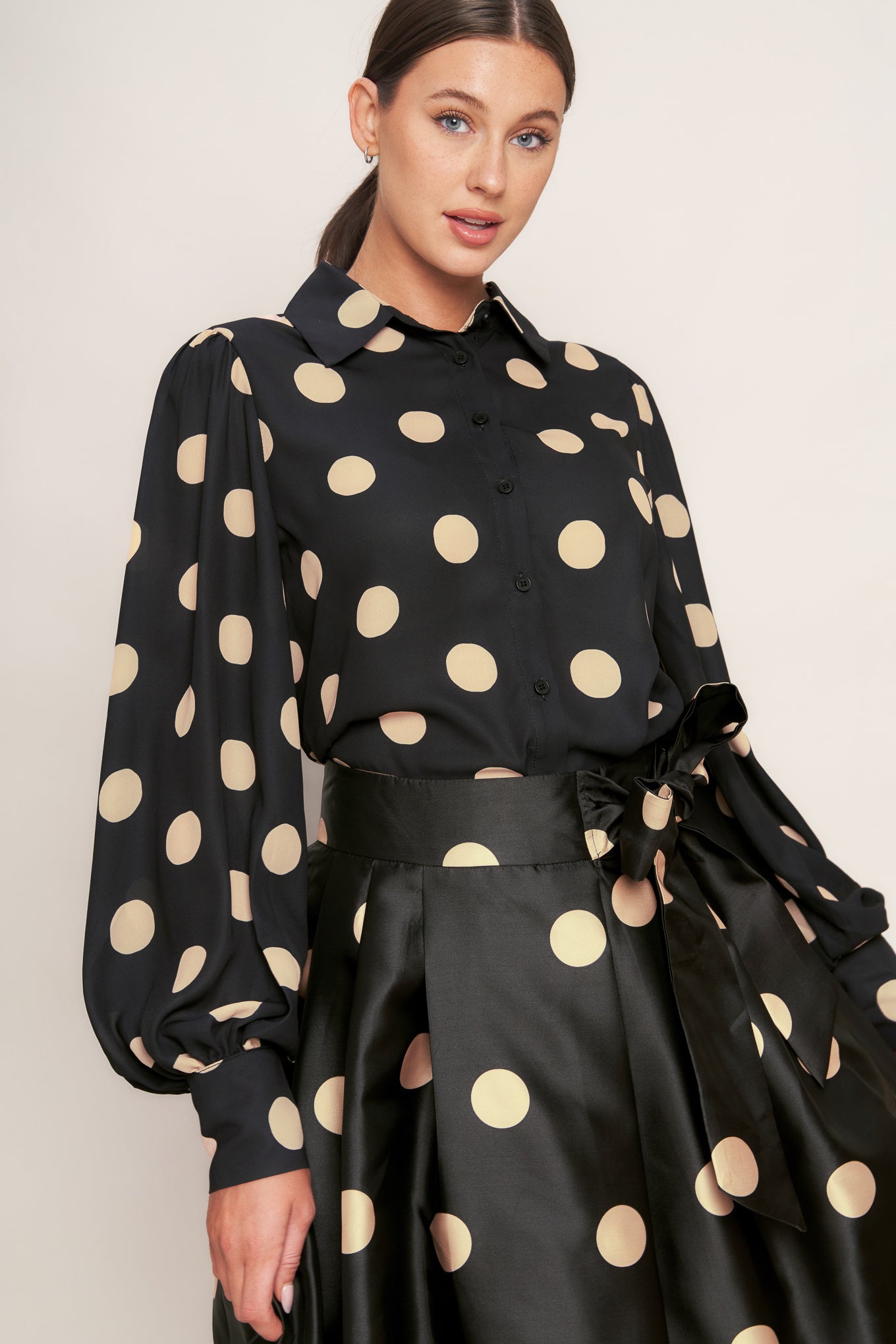A polka-dotted printed woven full midi skirt featuring side zipper closure with tie.