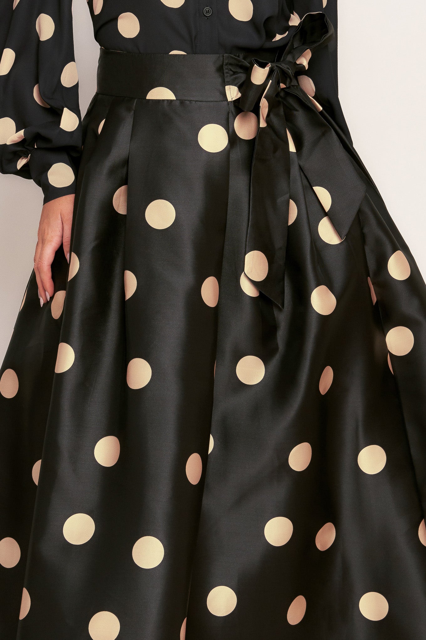 A polka-dotted printed woven full midi skirt featuring side zipper closure with tie.