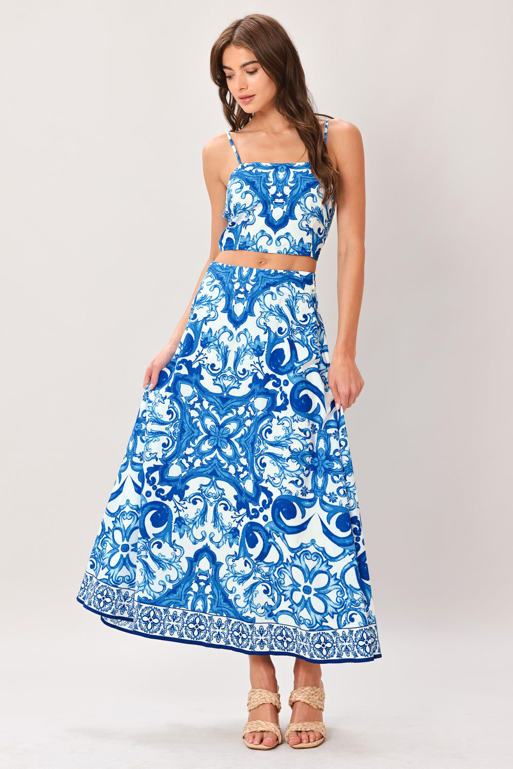 Woman wearing a blue and white patterned midi circle skirt with side zipper closure | Flying Tomato