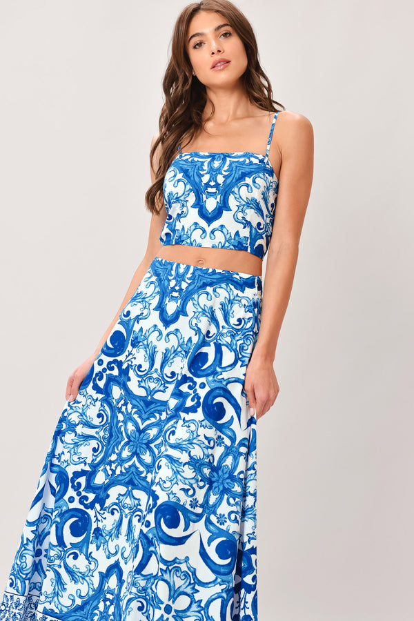 Woman wearing a blue and white patterned midi circle skirt with side zipper closure | Flying Tomato