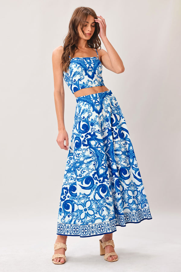 Woman wearing a blue and white patterned midi circle skirt with side zipper closure | Flying Tomato