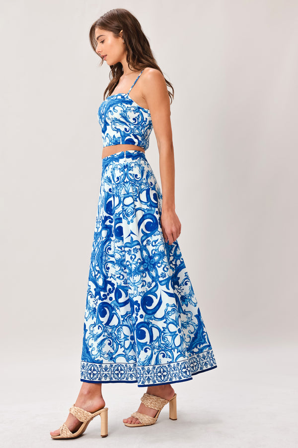 Woman wearing a blue and white patterned midi circle skirt with side zipper closure | Flying Tomato