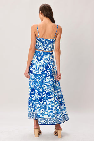 Woman wearing a blue and white patterned midi circle skirt with side zipper closure | Flying Tomato