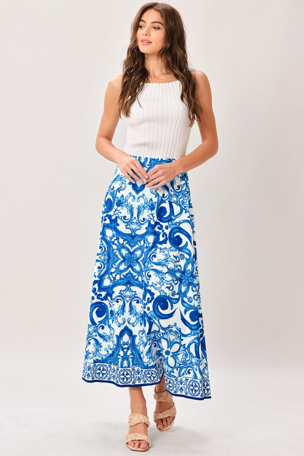 Woman wearing a blue and white patterned midi circle skirt with side zipper closure | Flying Tomato