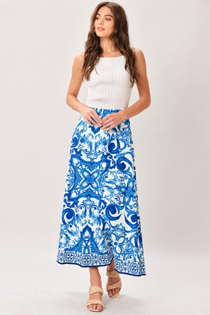 Woman wearing a blue and white patterned midi circle skirt with side zipper closure | Flying Tomato