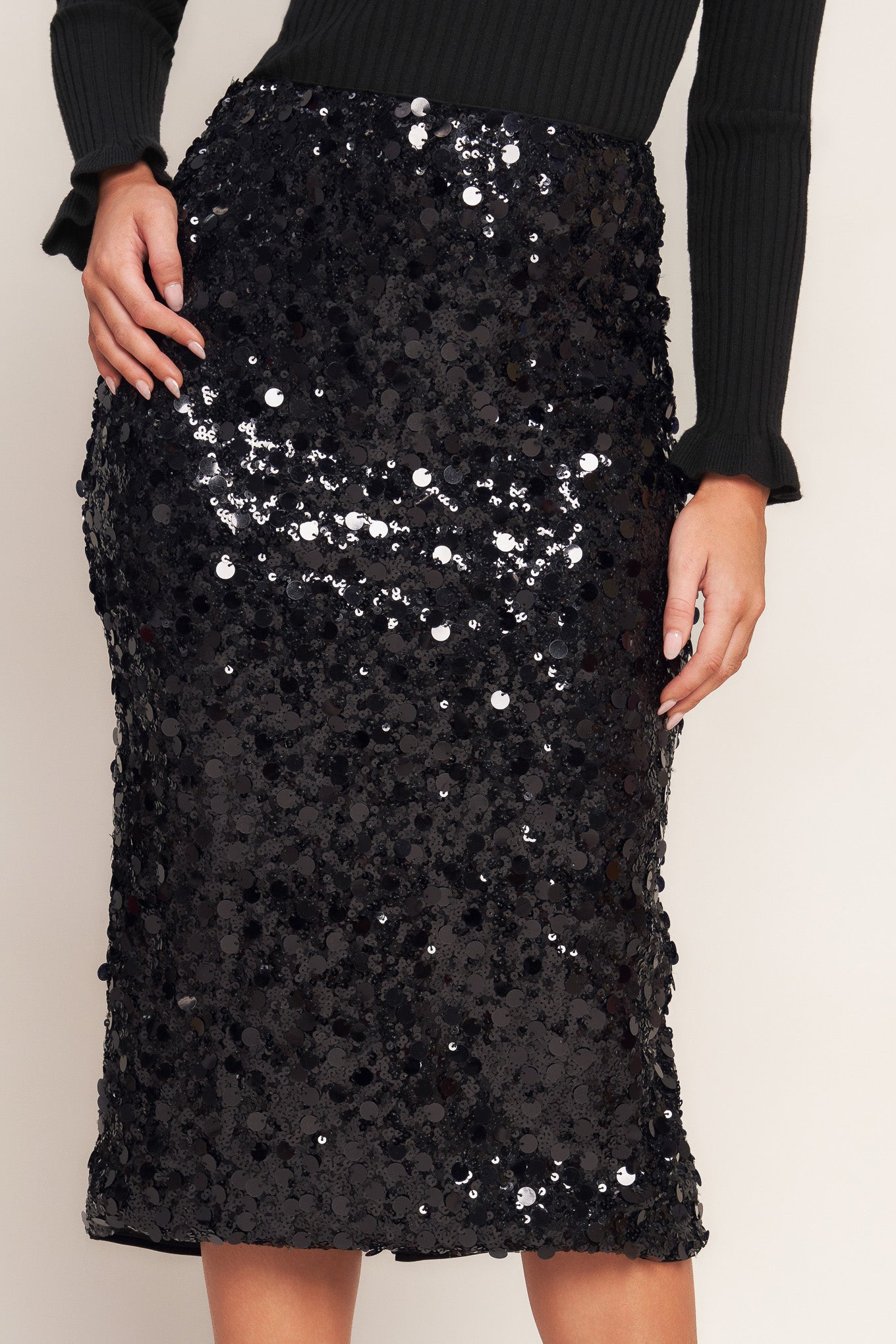 A sequin midi penil skirt with back zipper closure and slit