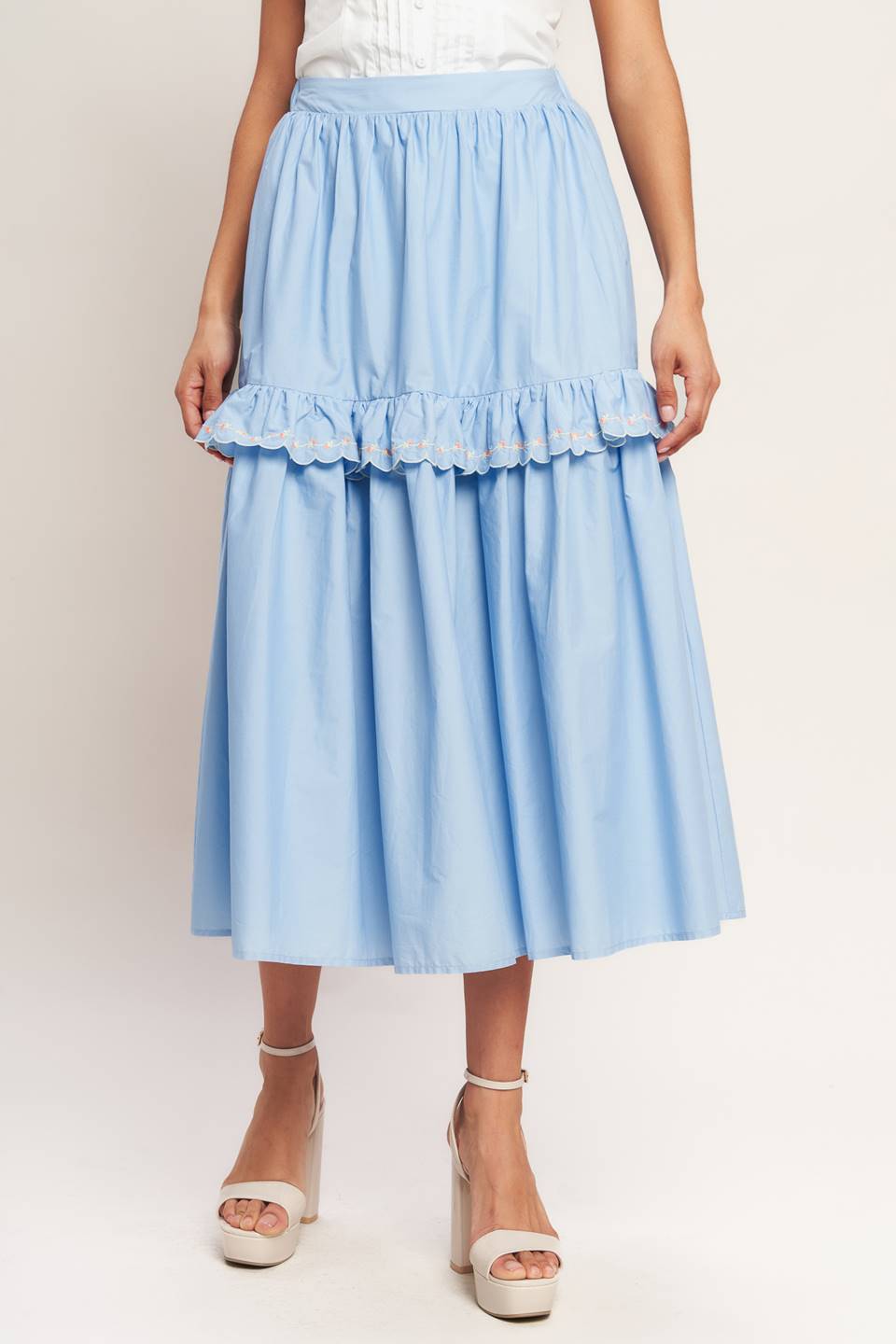 
A solid woven midi skirt featuring one tier skirt with embroidered ruffle and elasticized back waistband. Matching top IT14036B

Details:

Self : 100% Cotton
Lining : 100% Polyester

Size &amp; Fit

- Model is 5`8" And Wearing Size Small
- Measurements Taken From Size Small
- Approx. Length: 35" - Flying Tomato