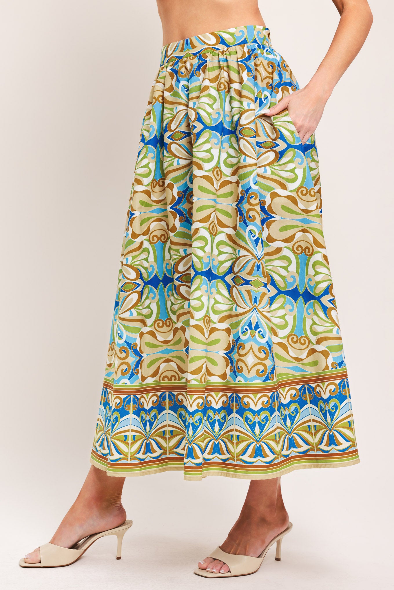 Woman wearing patterned full skirt with blue, green, and beige colors with elastic back waistband | Flying Tomato