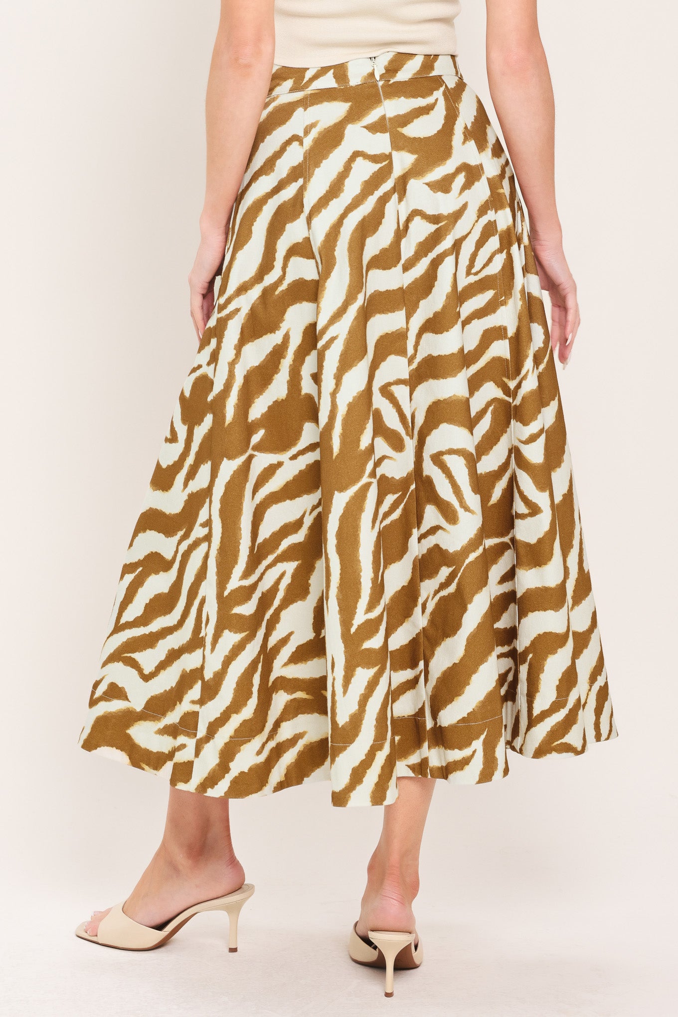 Woman wearing a light brown and taupe midi skirt with pockets and back zipper closure | Flying Tomato