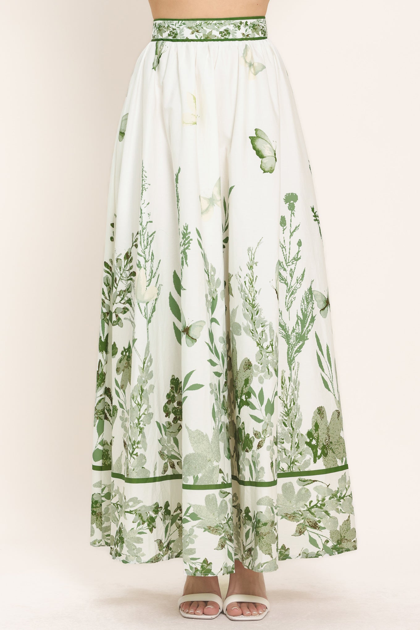 Woman wearing a long floral maxi skirt with green accents | Flying Tomato