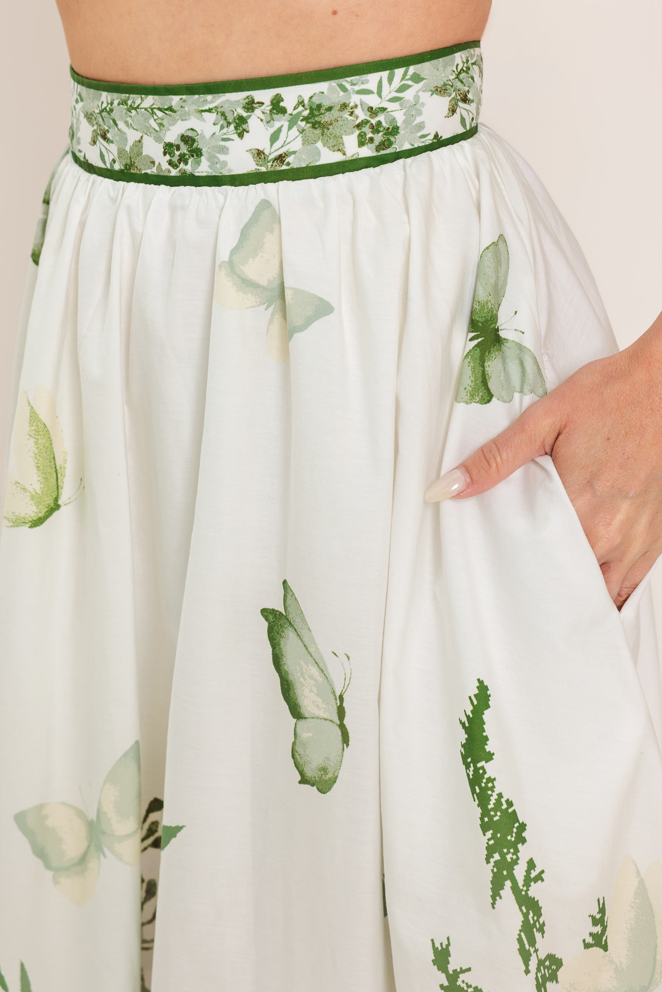 Woman wearing a long floral maxi skirt with green accents | Flying Tomato