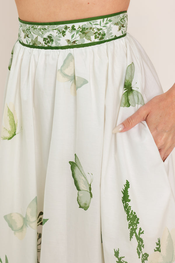 Woman wearing a long floral maxi skirt with green accents | Flying Tomato