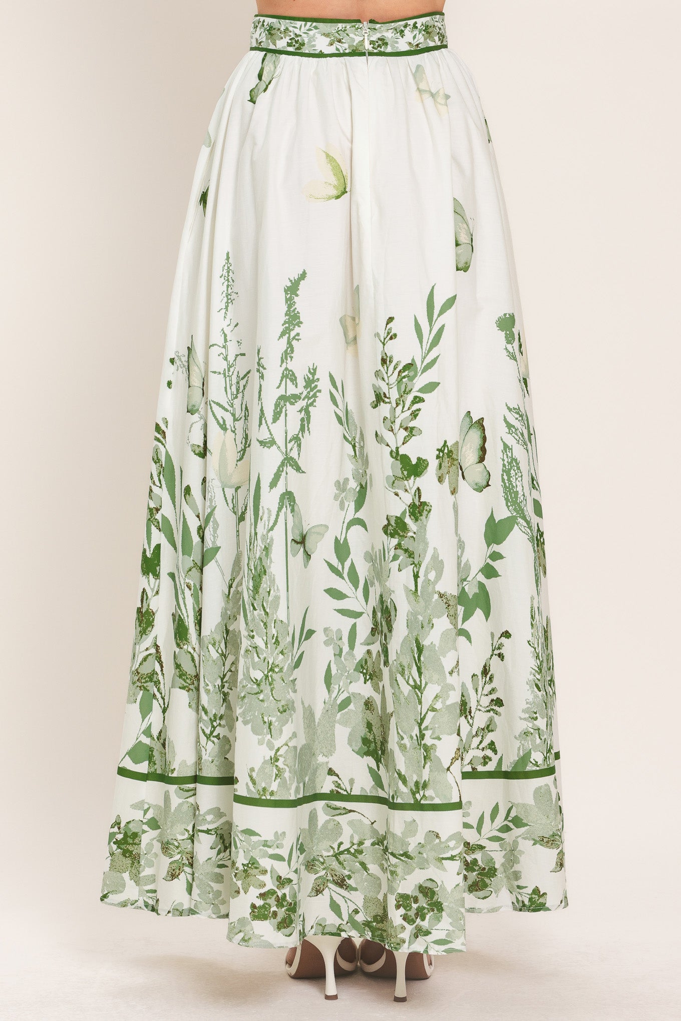 Woman wearing a long floral maxi skirt with green accents | Flying Tomato