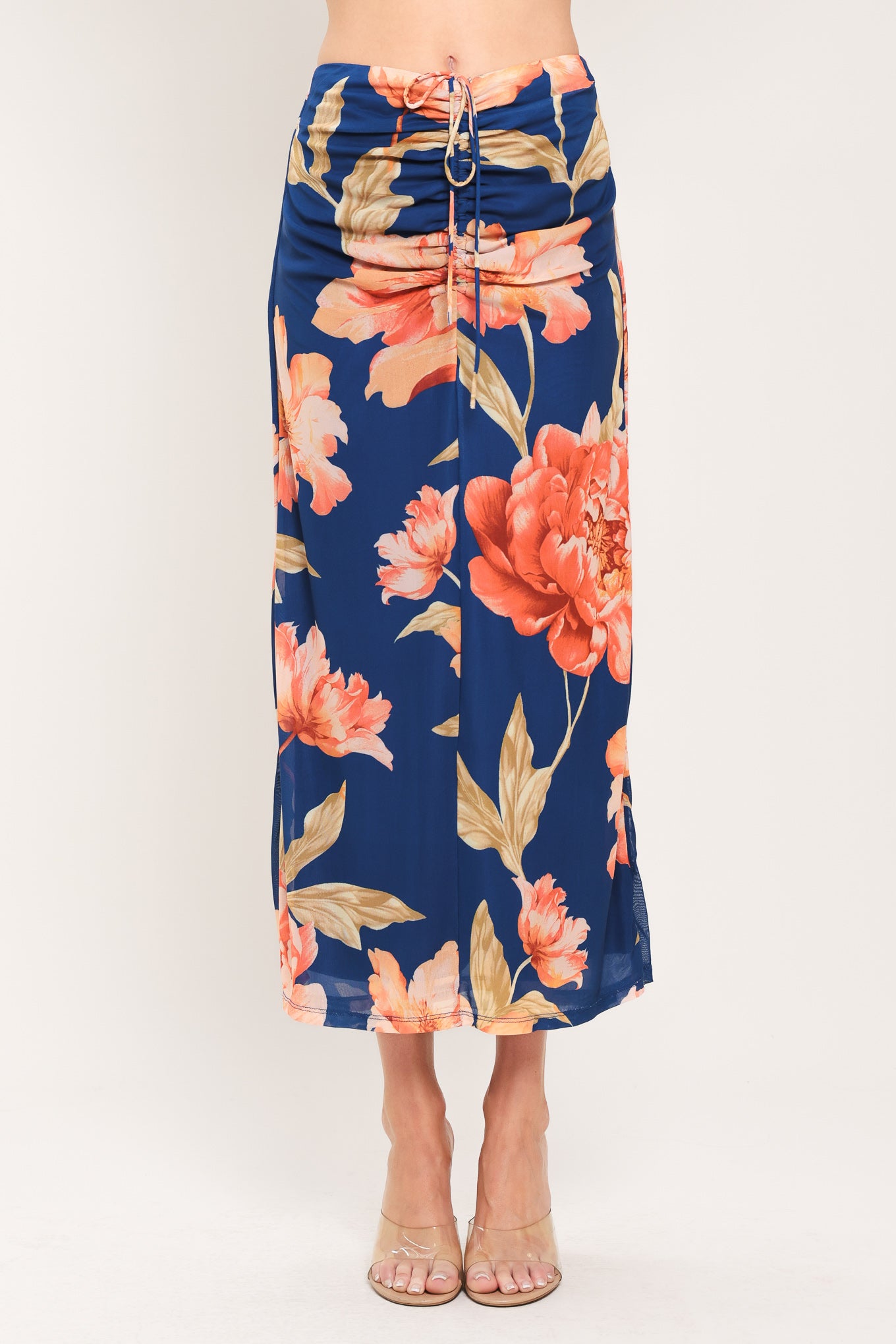 Woman wearing a navy blue with coral flowers power mesh midi skirt with front center shirring with tie and back zipper closure | Flying Tomato