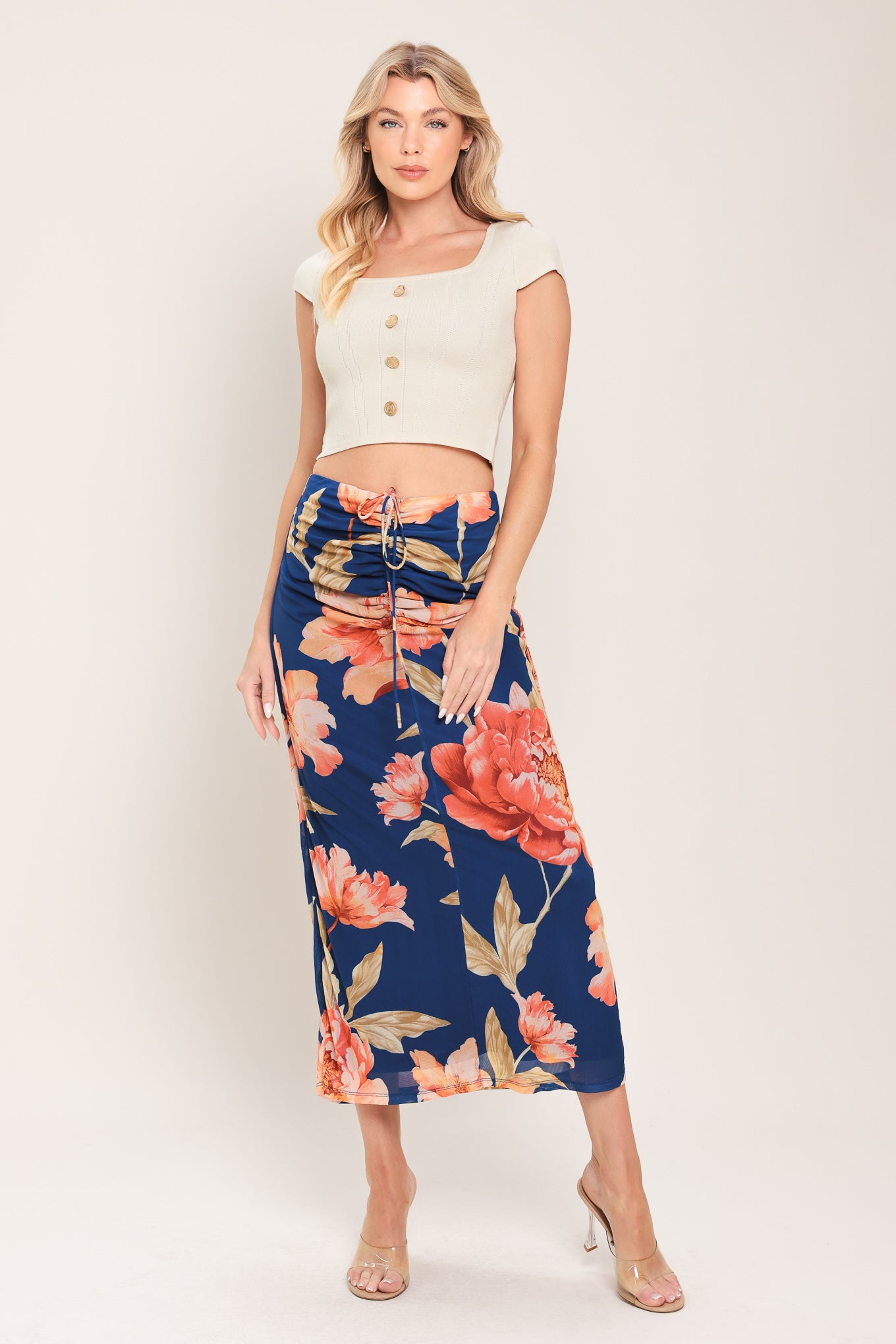 Woman wearing a navy blue with coral flowers power mesh midi skirt with front center shirring with tie and back zipper closure | Flying Tomato