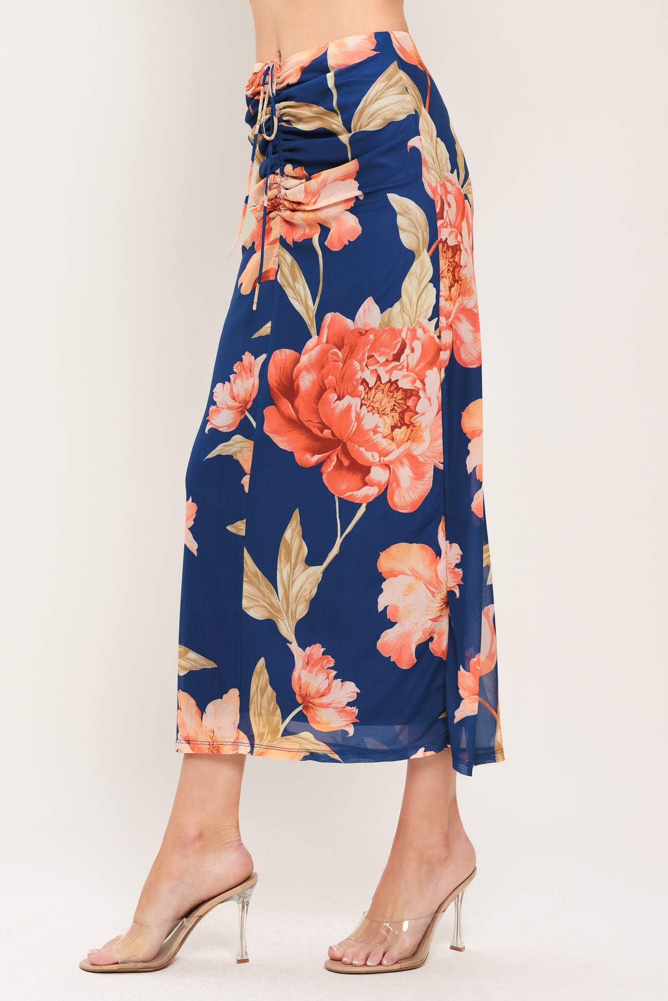 Woman wearing a navy blue with coral flowers power mesh midi skirt with front center shirring with tie and back zipper closure | Flying Tomato
