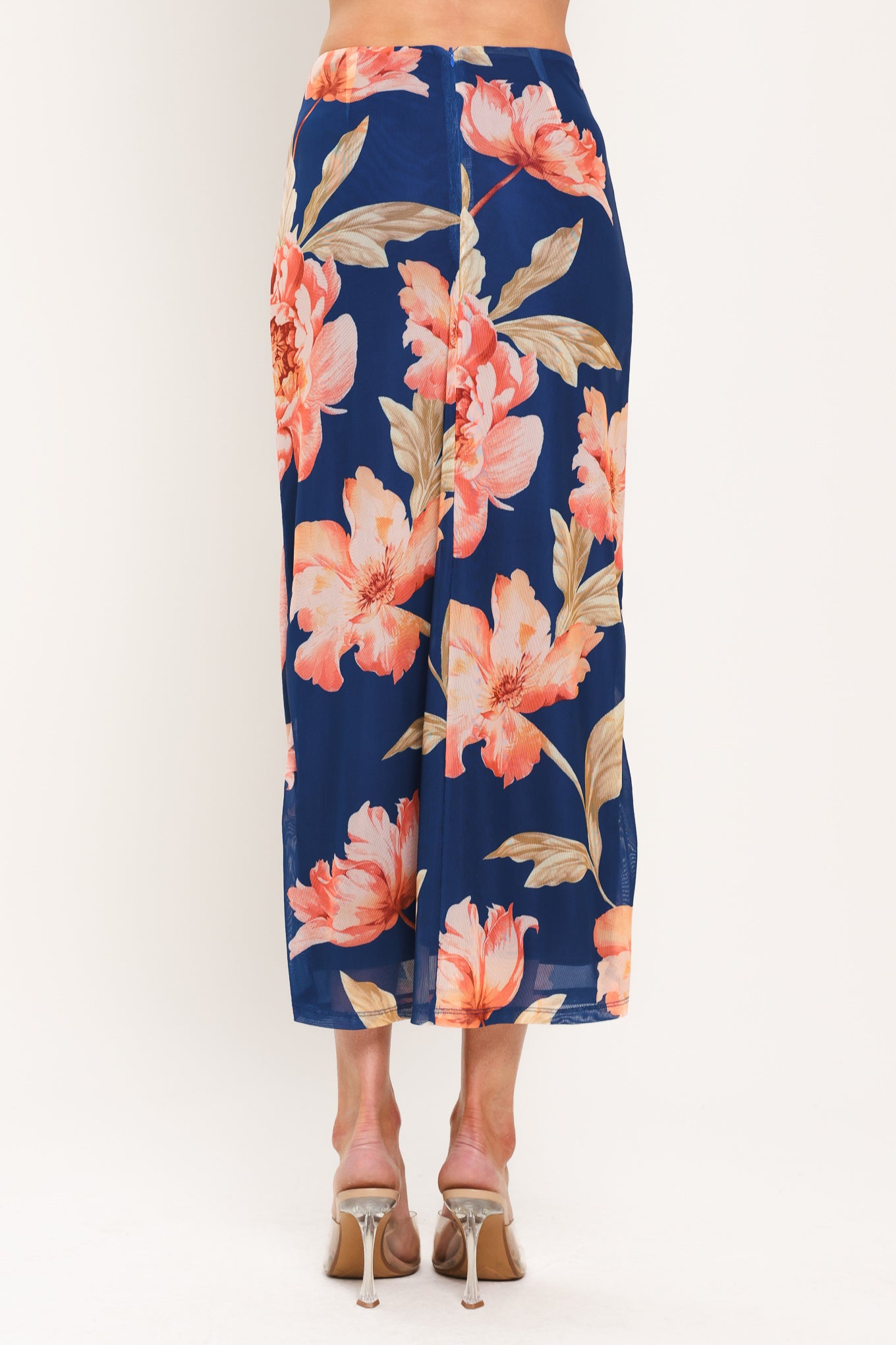 Woman wearing a navy blue with coral flowers power mesh midi skirt with front center shirring with tie and back zipper closure | Flying Tomato