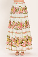 Woman wearing a pink, green and white floral print woven maxi skirt with tiers and smocked back waistband | Flying Tomato