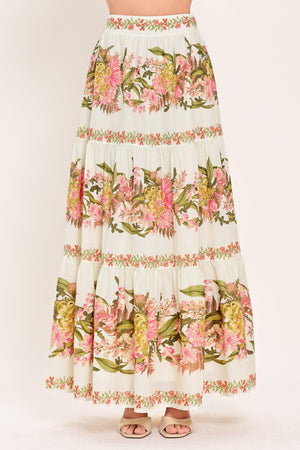 Woman wearing a pink, green and white floral print woven maxi skirt with tiers and smocked back waistband | Flying Tomato