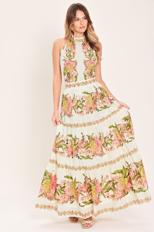 Woman wearing a pink, green and white floral print woven maxi skirt with tiers and smocked back waistband | Flying Tomato