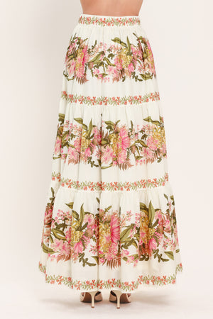 Woman wearing a pink, green and white floral print woven maxi skirt with tiers and smocked back waistband | Flying Tomato