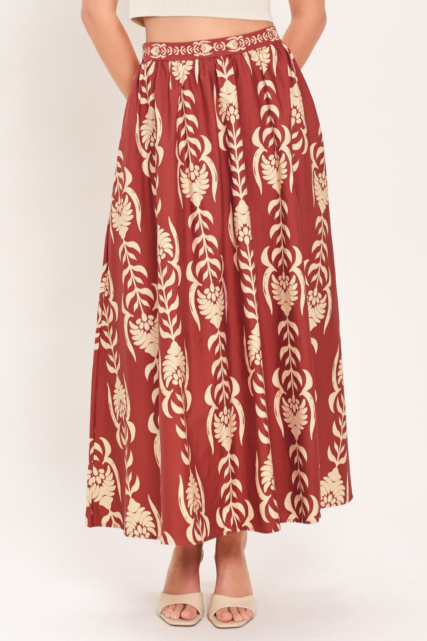 Woman wearing a burgundy ankle skirt with beige floral pattern | Flying Tomato