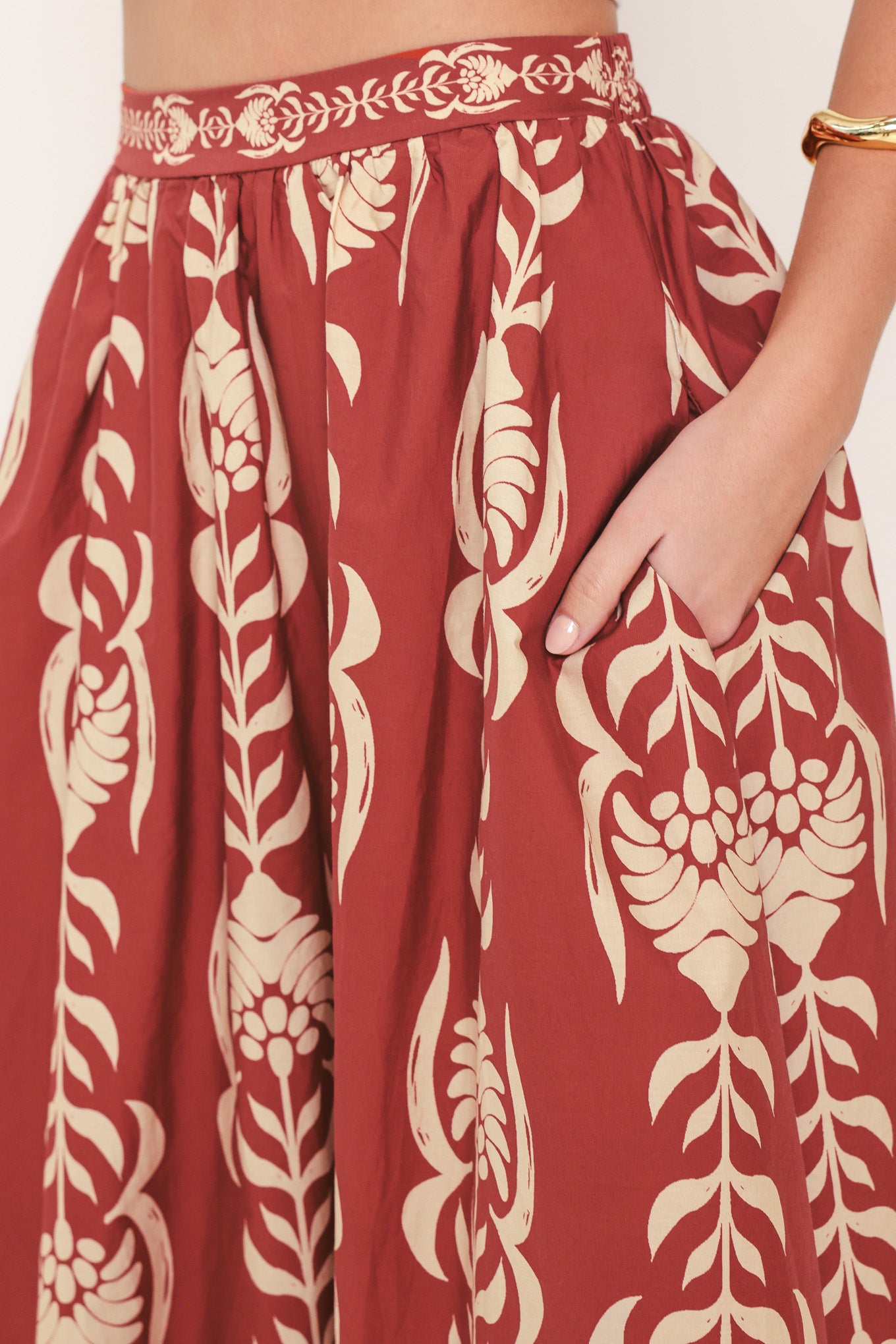 Woman wearing a burgundy ankle skirt with beige floral pattern | Flying Tomato