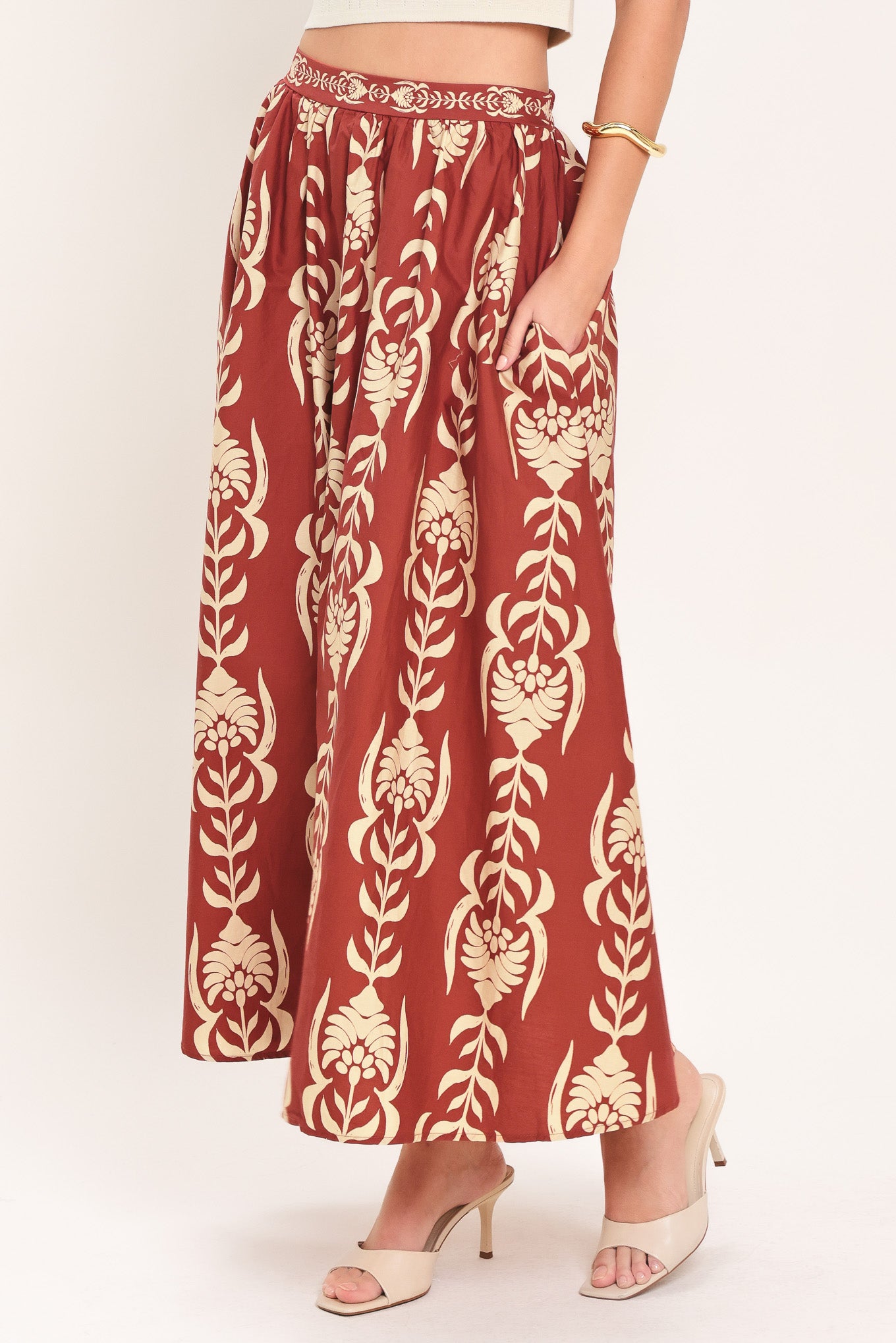 Woman wearing a burgundy ankle skirt with beige floral pattern | Flying Tomato