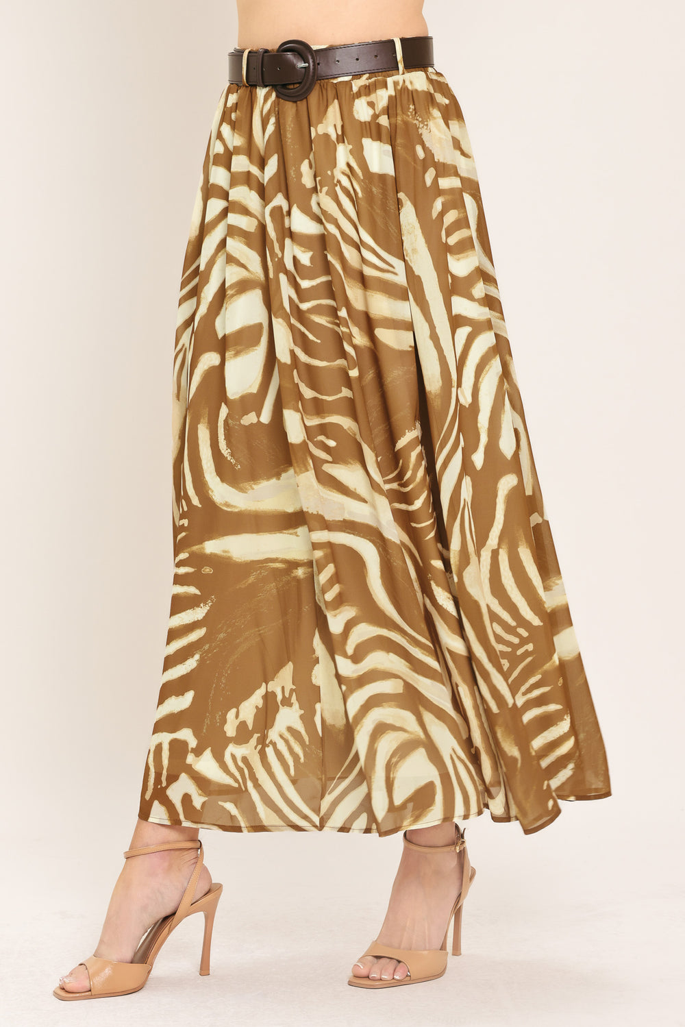 Woman wearing a mocha and taupe zebra print midi skirt with a belt | Flying Tomato
