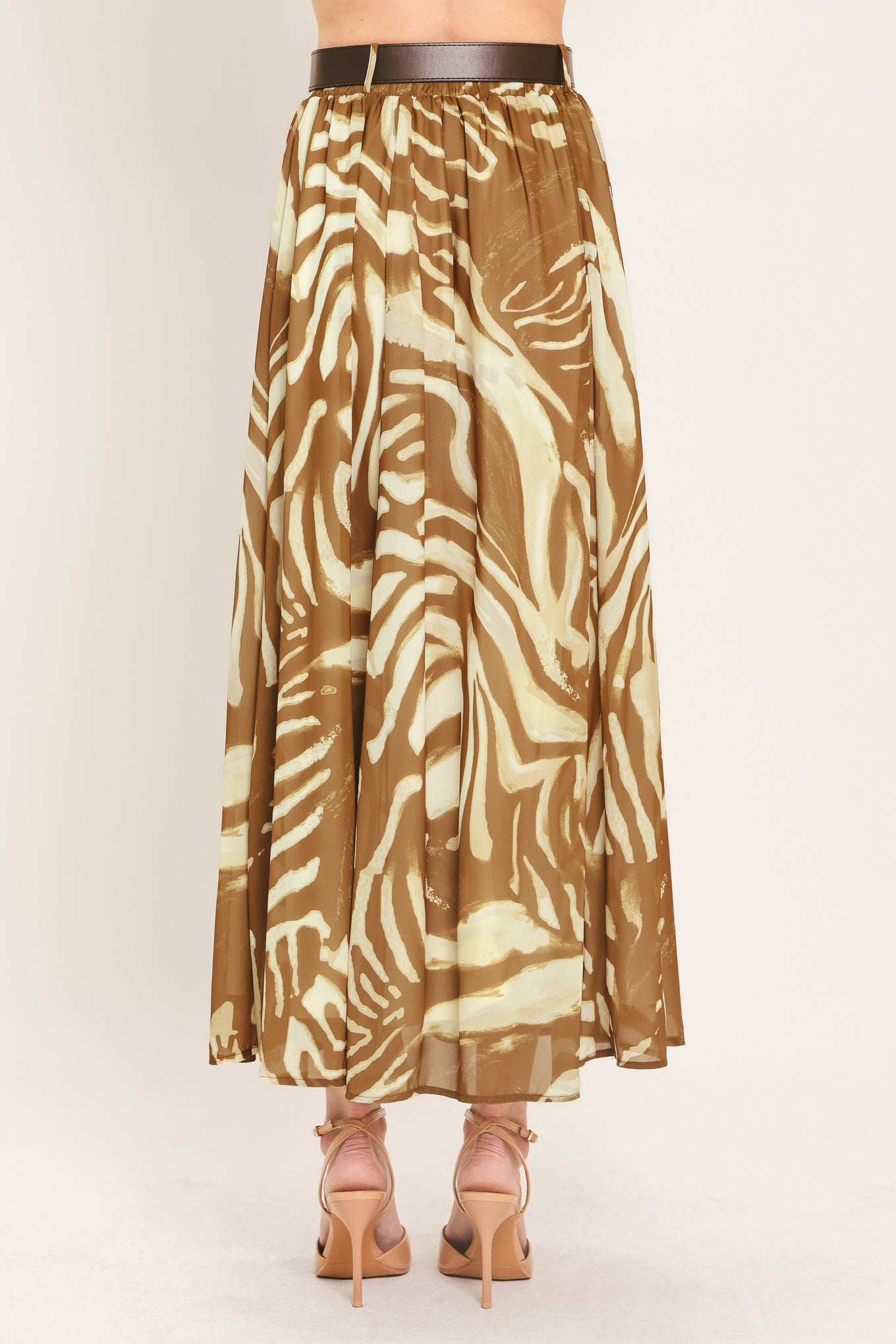 Woman wearing a mocha and taupe zebra print midi skirt with a belt | Flying Tomato