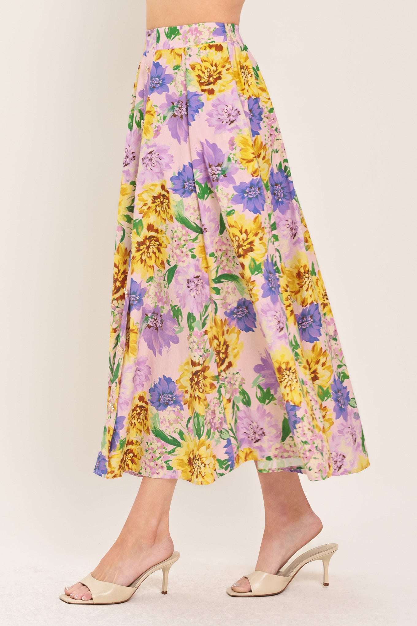 Woman wearing a yellow and purple floral patterned full midi skirt with front button detail and smocked back waistband | Flying Tomato