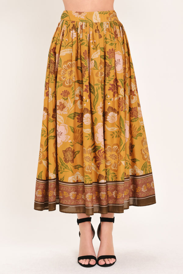 Woman wearing a mustard yellow floral patterned midi skirt | Flying Tomato